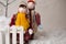 Two plush children standing by the fence in a Christmas arrangement