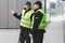 Two police officers in reflective vests patrol the streets of the city