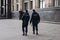 Two policemen walk around the city in the direction from the viewer, we see their backs with the inscription in Russian -