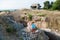 Two poor refugee children boy girl on ruins building destroyed by earthquake