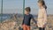 Two poor refugee children standing by the sea in war conflict zone. boy and girl waiting to be rescued