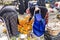 Two poor women are trying to select some good fruits on floor