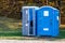 Two portable toilets in a park