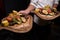 Two portions baked vegetables on a wooden tray