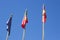 Two Portuguese Flags and a European Flag hang in the still air of a calm day outside a hotel in Albuferia in Portugal