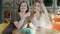 Two positive happy women posing at table in cafe. Portrait of smiling charming Caucasian friends looking at camera