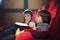 Two preschool children, twin brothers, watching movie in the cinema