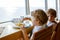 Two preschool kids boys eats pasta sitting in cafe on cruise ship