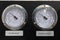Two pressure gauges on a black background close-up