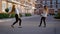 Two pretty ballet dancer girls is practicing their performance in front of modern living houses in a city in evening