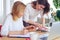 Two pretty businesswomen looking through catalog of color palette