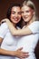 Two pretty diverse girls happy posing together: blond and brunette on brown background, lifestyle people concept