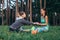 Two pretty female friends practicing yoga together doing wide leg seated forward bend in the open air