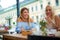 Two pretty girlfriends laughing while sitting in a bar