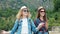 Two pretty girls young women friends travelers walk outdoors on mountain scene