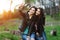 Two pretty and happy young woman using mobile phone in the park. Best friends make selfie.