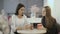 Two pretty ladies dicussing something sitting at table in cafe