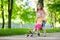 Two pretty little sisters having fun together learning to skateboard outdoors