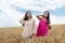 two pretty sister enjoy freedom in wheat field