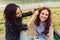 Two pretty sisters girls having fun together, field flowers in hair