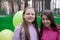 two pretty teenage girls friends with colorful balloons in park. happy kids. summer days. vacation, holidays. friendship