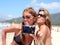 Two pretty young girlfriends taking a photo of themselves with c