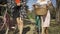 Two pretty young women walking outdoors. Girls talking while leading their bicycles on the narrow road on the street