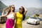 Two pretty young women by white cabriolet car