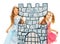 Two princesses behind cardboard castle tower