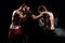 Two professional boxer boxing on black smoky background,