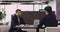Two professional businessmen wear suits negotiating sit at office table