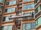 Two Professional workers use a suspended cradle or steeplejack to access and clean windows of typical high rise building or