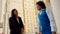 Two professionals in a discussion meeting hand shaking beside a building businessman businesswomen