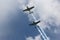 Two Propeller Powered Planes Smoking and Flying Through the Clouds