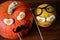 Two pumpkins faces Halloween decorations wooden background