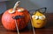 Two pumpkins faces Halloween decorations wooden background