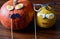 Two pumpkins faces Halloween decorations wooden background