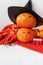 Two pumpkins with a painted face in a hat, a spider, a wooden calendar on a red sweater. Holiday concept of October 31, Halloween