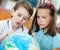 Two pupils look at the globe