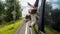 Two puppies travel in a car with the owner, a hand with the American flag peeps out of the window