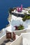 Two purple chairs on balcony of Santorini island cliff