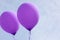 Two purple helium apart ballons horizontal