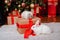 Two rabbits, a white albino and a lop-eared one, are sitting on the background of a Christmas tree