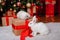 Two rabbits, a white albino and a lop-eared one, are sitting on the background of a Christmas tree