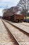 Two railroad tracks and rail cars travelling the distance.