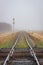 Two Railroads Crossing With Track Receding into Fog