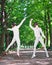 Two rapier fencer women fighting over park alley