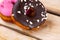 Two raspberry and chocolate donuts on a wooden background. Free space for text. World donut day