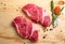 Two raw beef neck steak on wooden background