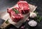 Two raw fresh marbled meat black angus steak ribeye, garlic, salt